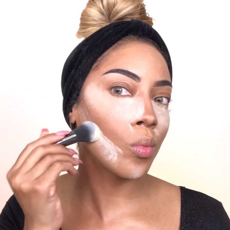 A girl applying makeup on her face using Vasanti Stubby Fluff Brush